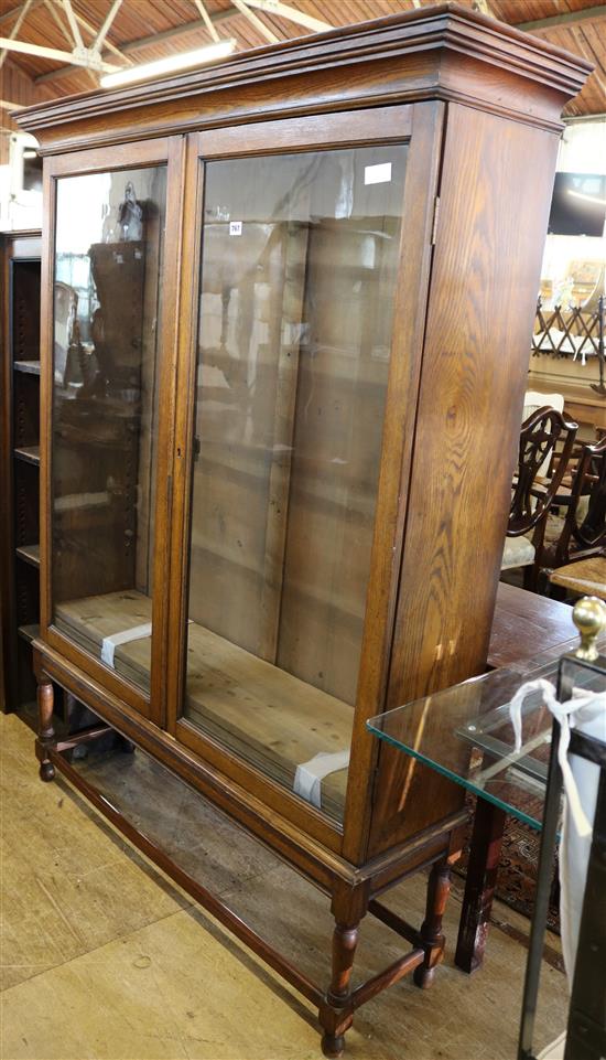 Edwardian oak cabinet/bookcase with glazed doors, on turned legs & stretcher